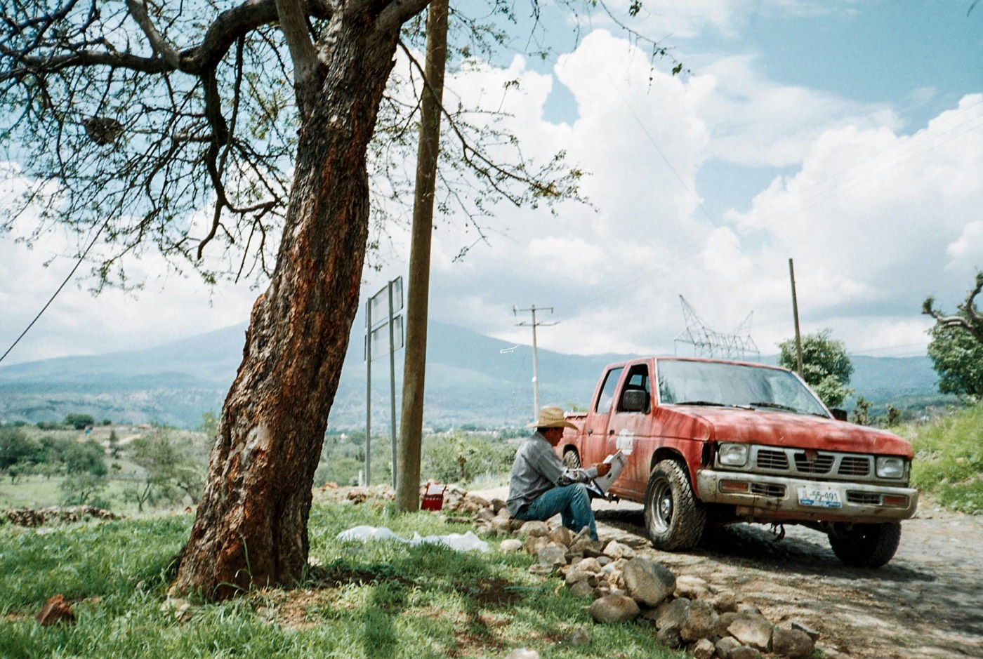 Camioneta de trabajo en un camino rural con la sierra al fondo